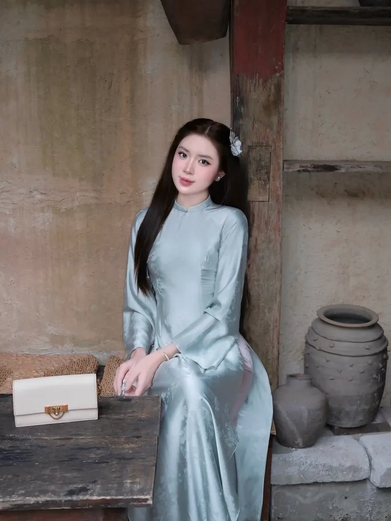 Ánh mắt cuốn hút của cô gái lấp ló sau tà áo dài mỏng manh trước gió