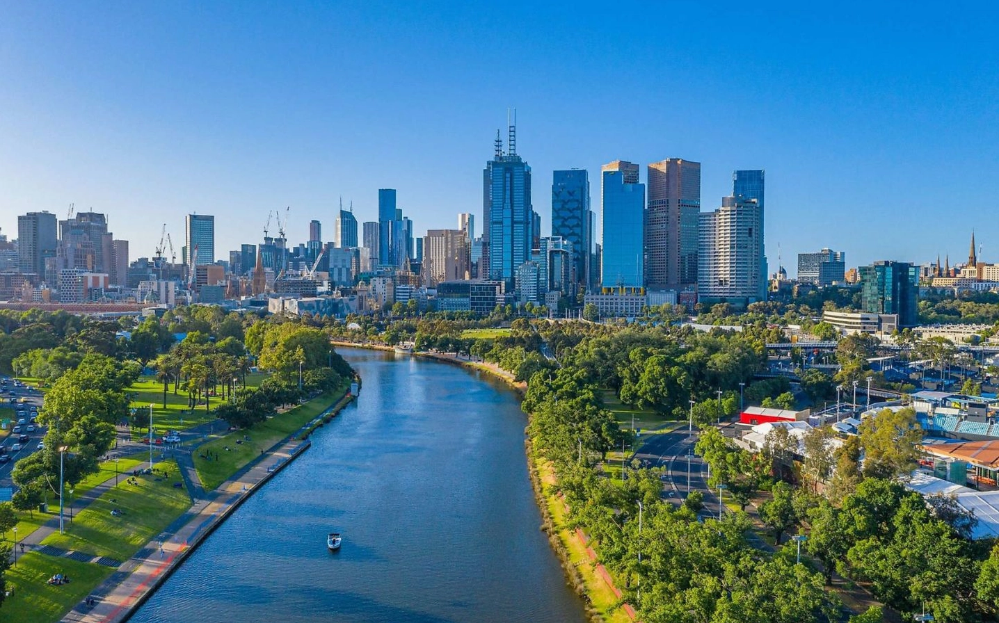 Ảnh nền phong cảnh thành phố bên sông với skyline hiện đại dưới trời xanh trong vắt
