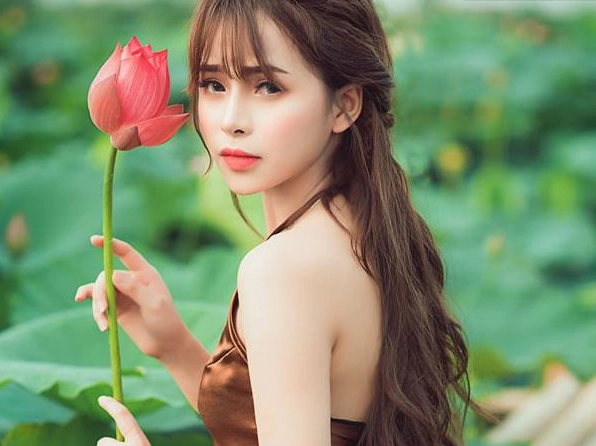 Cô gái mặc áo yếm đỏ rực rỡ khoe lưng trần quyến rũ bên hồ sen ngát hương