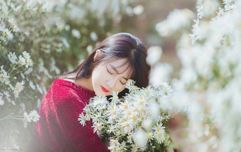 Cô gái xinh đẹp cầm hoa dạo bước trong khung cảnh thiên nhiên thơ mộng