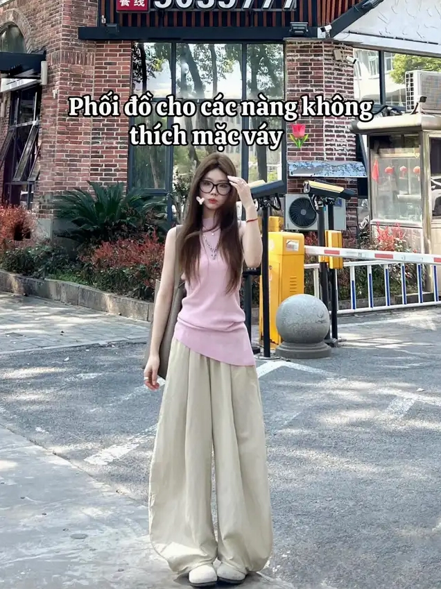 Cô nàng sành điệu đeo kính diện áo tank top hồng bất đối xứng dạo bước trên phố