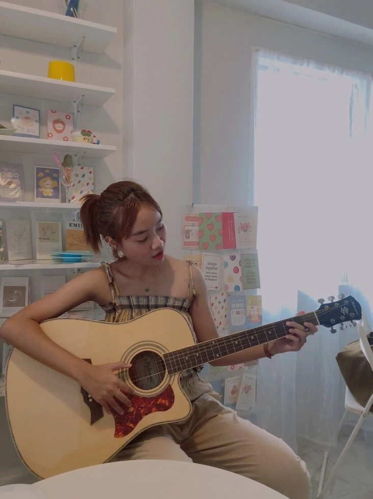 Cô nàng xinh xắn làm quen với các hợp âm và nhịp điệu của cây đàn guitar mộc mạc