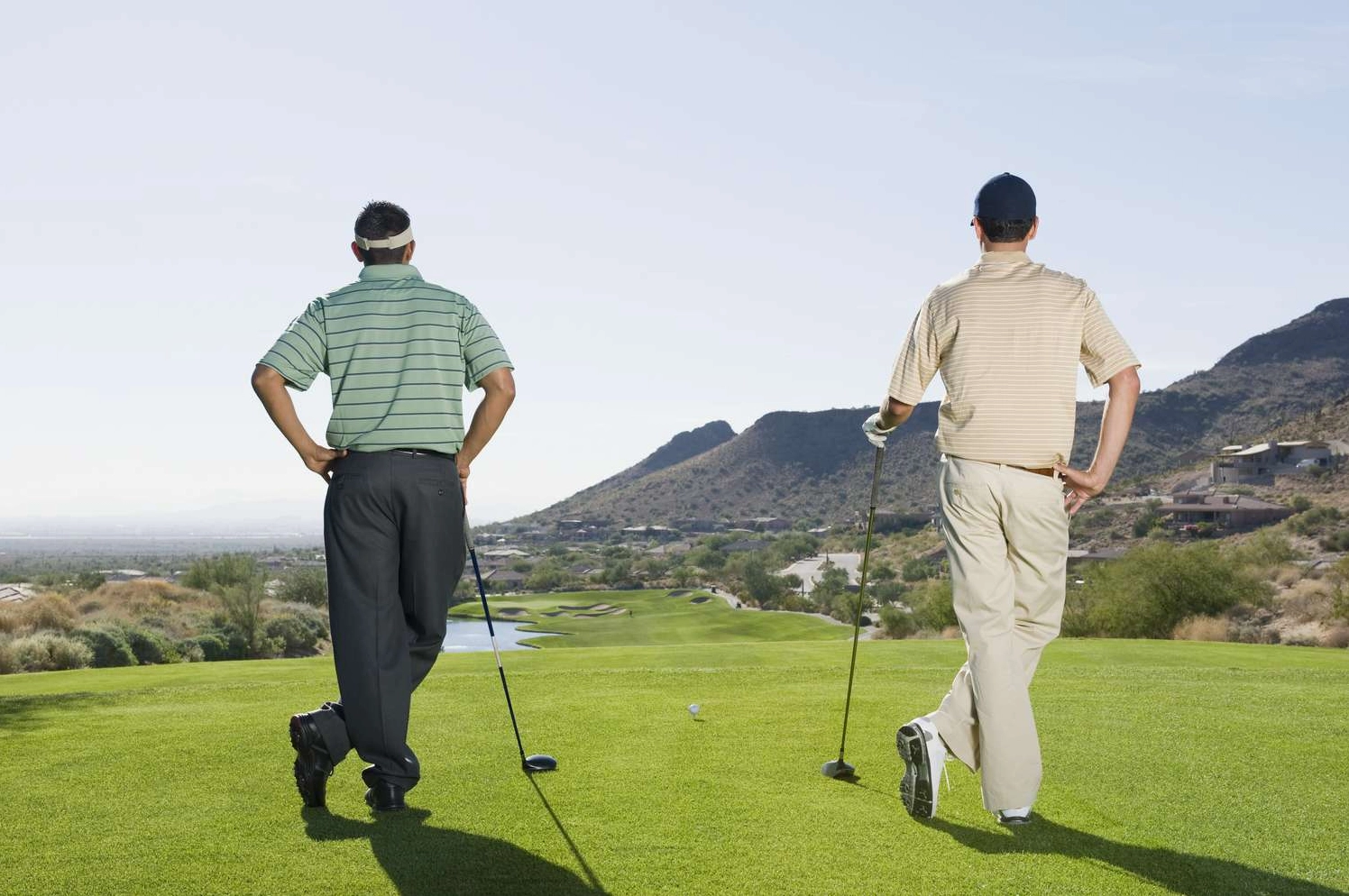 Hai người chơi golf đang vui vẻ trò chuyện trên sân
