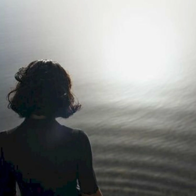 Hình ảnh cô gái tóc ngắn ngồi quay lưng trầm ngâm suy nghĩ