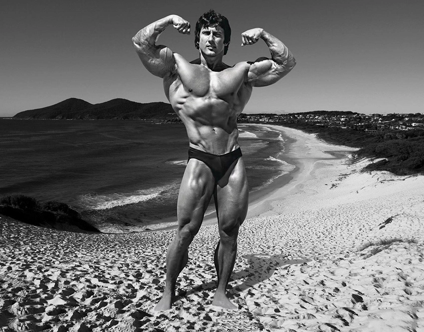 Hình ảnh Frank Zane khoe cơ bắp săn chắc trên bãi biển