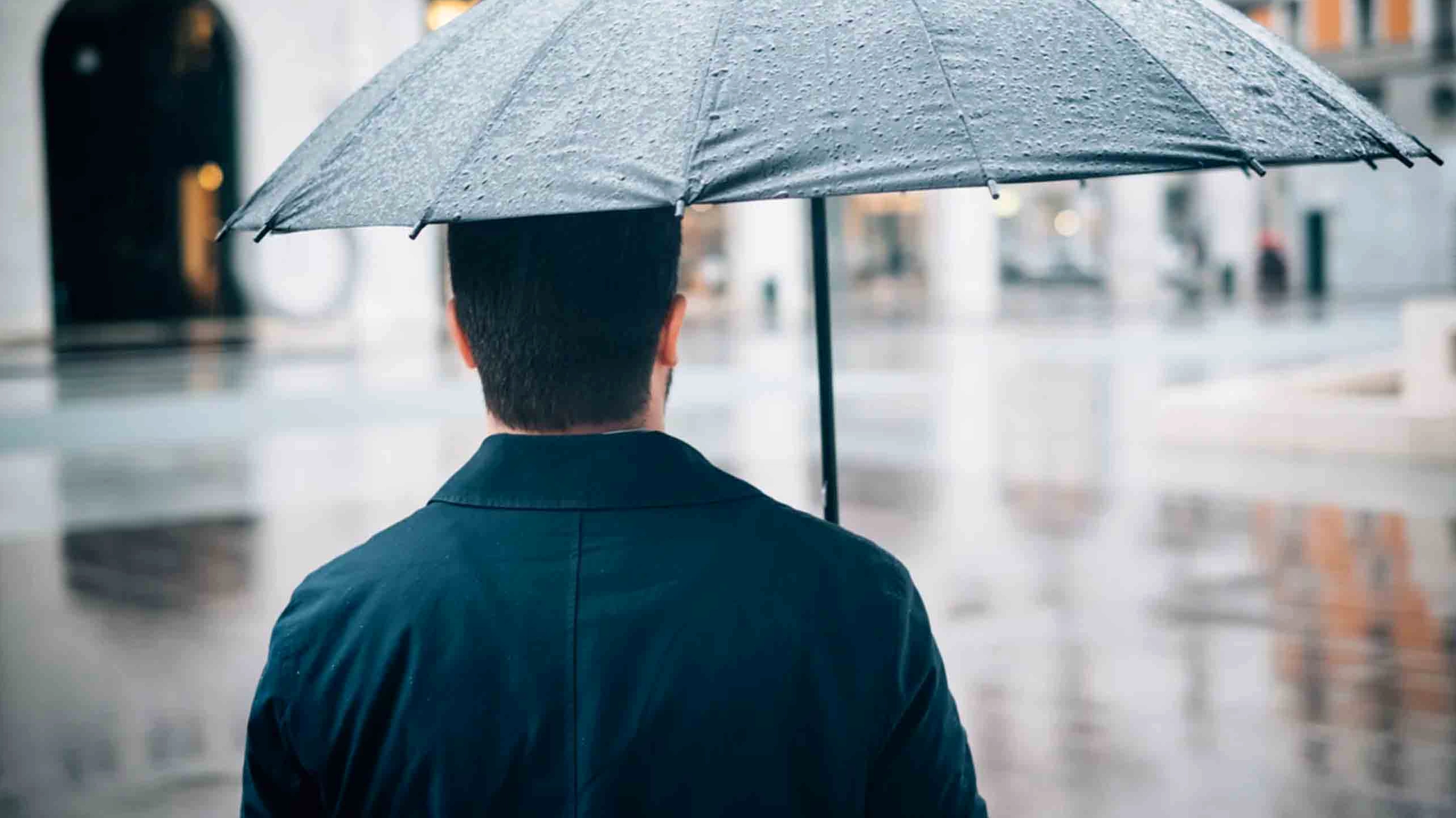 Khung cảnh buồn bã khi một người con gái bước đi dưới trời mưa tầm tã