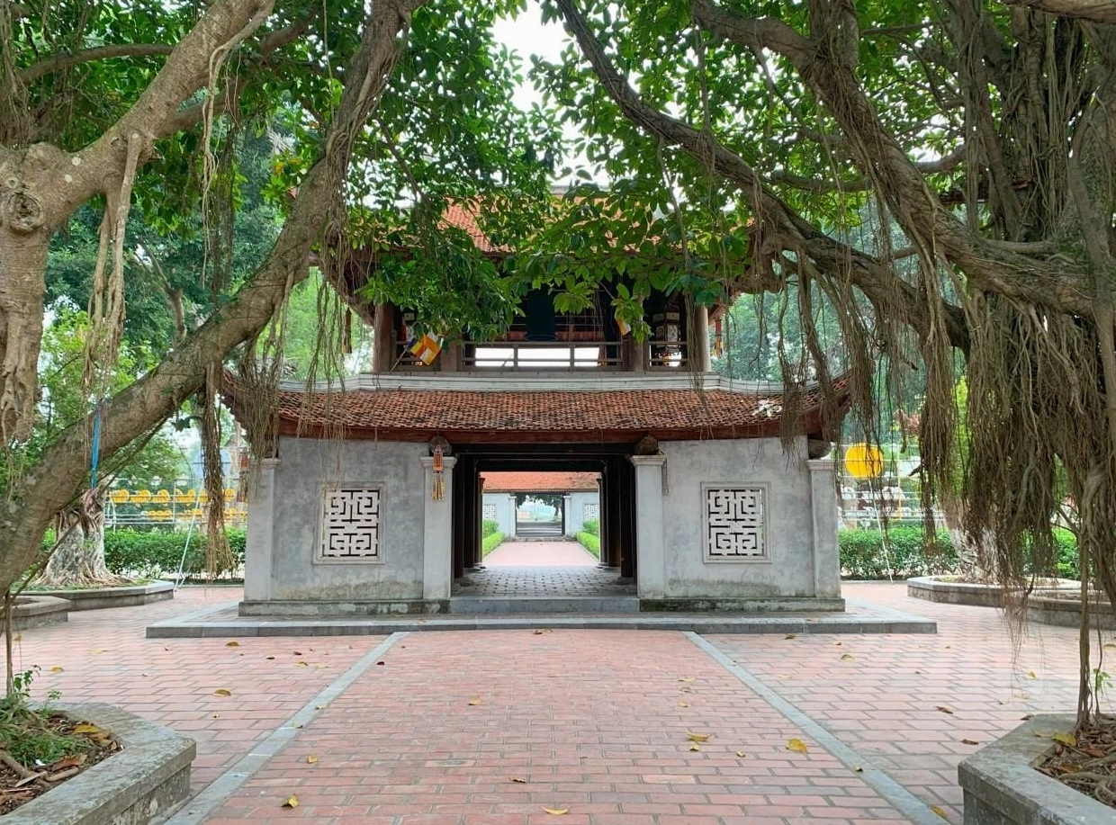 Lối vào cổng chùa Bút Tháp rợp bóng cây xanh mát và thanh bình