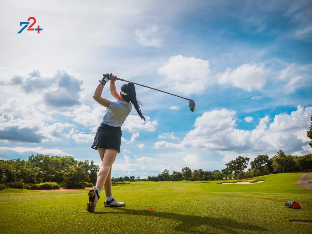Một tay golf nam mặc trang phục chỉnh tề đang chuẩn bị đánh bóng