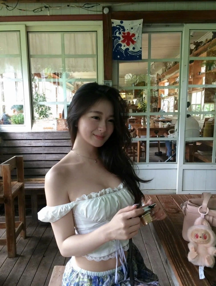 Nàng thơ với mái tóc dài thướt tha trong gió nhẹ nhàng che đi nụ cười mỉm duyên dáng