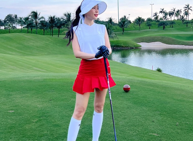 Người mẫu thể thao tự tin sải bước trên sân golf với trang phục váy xếp ly chuyên dụng