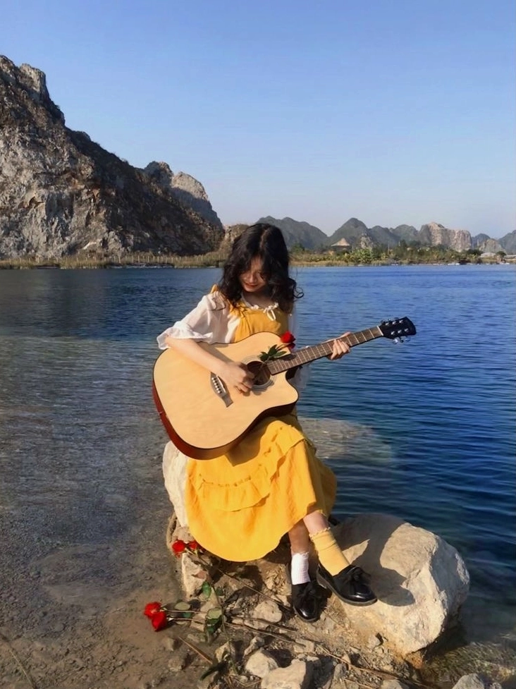 Thiếu nữ chơi đàn guitar tạo phong cách âm nhạc riêng biệt và tự tin thể hiện bản thân