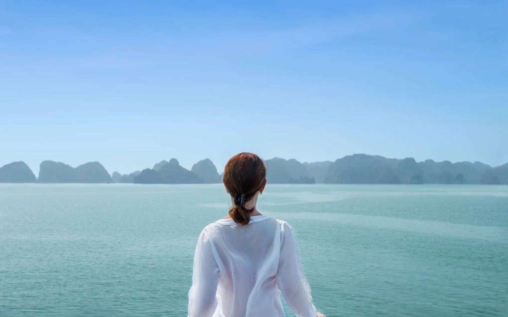 Thiếu nữ đứng cô đơn trước biển rộng lớn với tông màu xanh lạnh lẽo